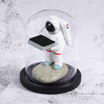 Decorative watch display stand with small astronaut figurine under glass dome for stylish storage.